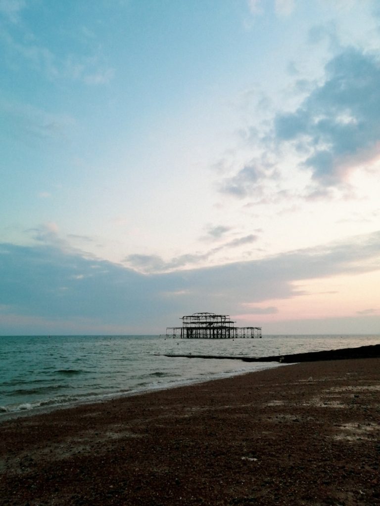 a beach with a pier in the distance